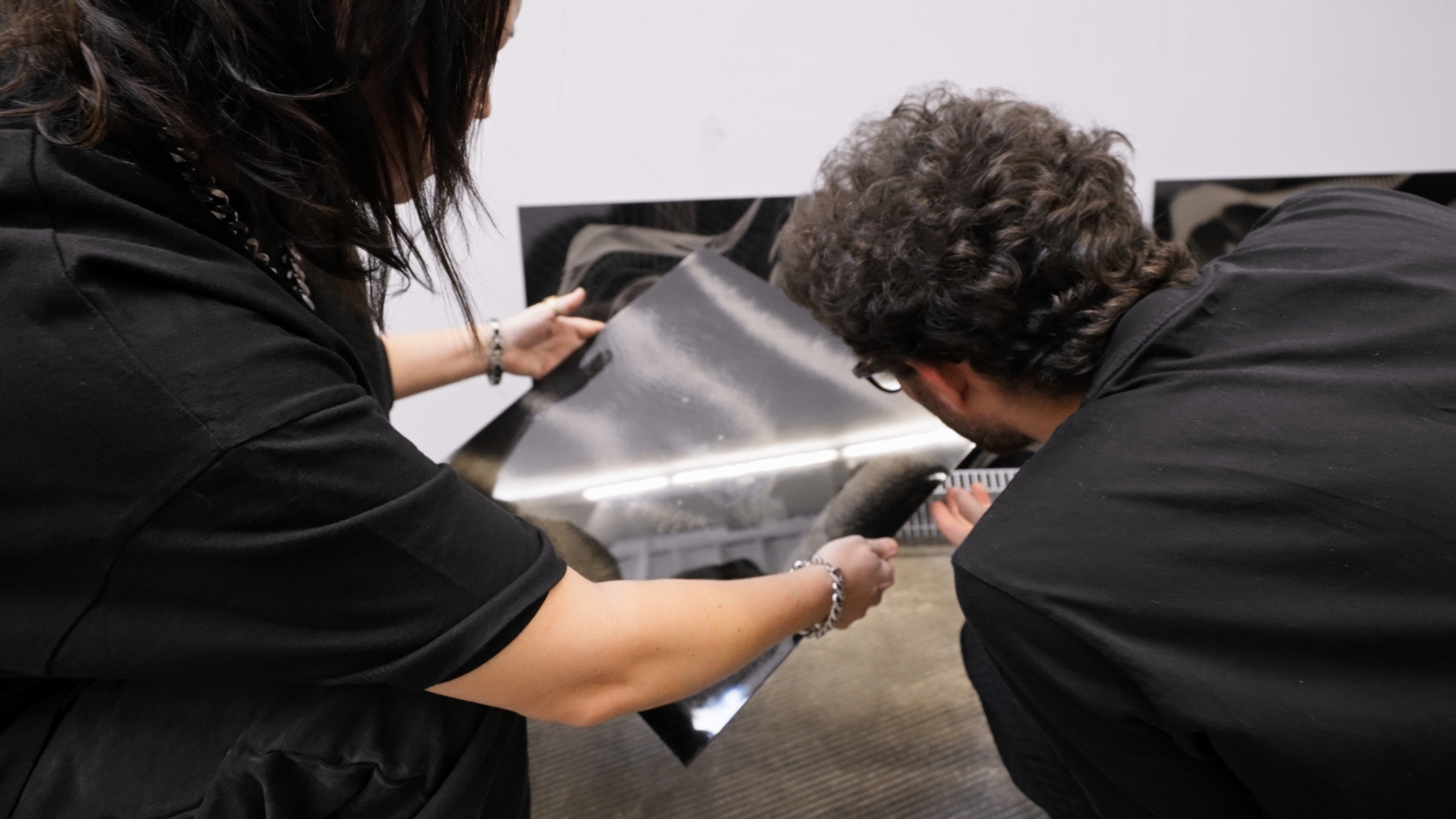 The artists inspecting one of the final physical artworks.